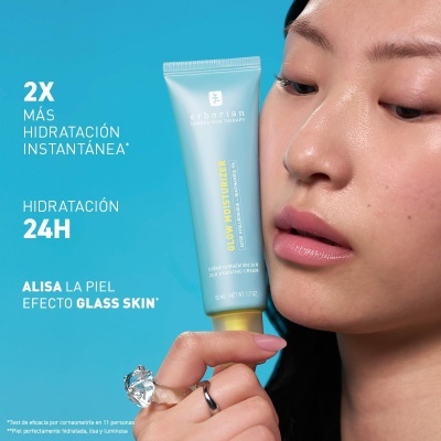 Mulher segurando tubo azul de creme hidratante Arhorian Glow Moisturizer com fundo azul