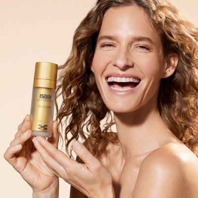 Mulher sorridente segura produto ISDIN MELATONIC dourado