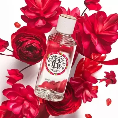 Frasco de perfume Roger & Gallet rodeado por flores vermelhas