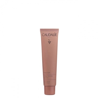 Tube de creme Caudalie cor de rosa com texto impresso sobre fundo branco