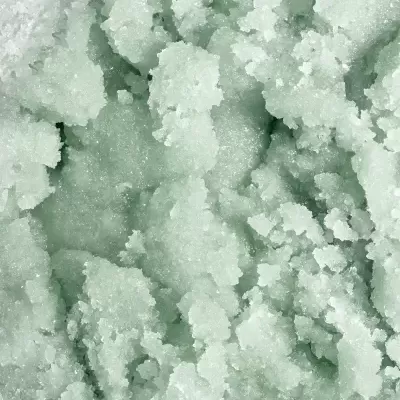 Substância granular esverdeada, textura áspera, aparente produto esfoliante