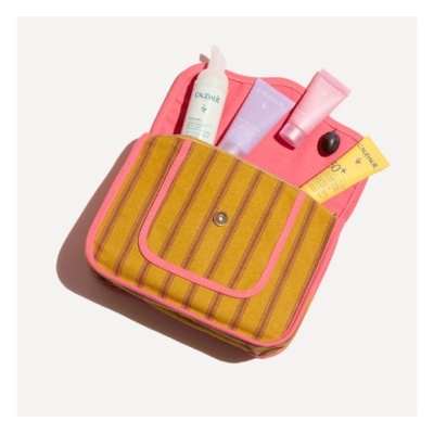 Bolsa amarela com riscas e produtos Caudalie