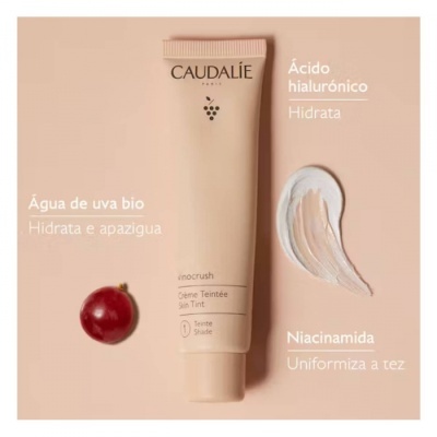 Tubo creme tonificante Caudalie Vinocrush com textura e uva em fundo rosa