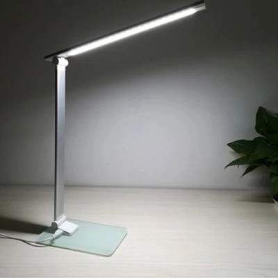 Lâmpada de mesa branca com base de vidro fosco e planta verde em fundo cinzento
