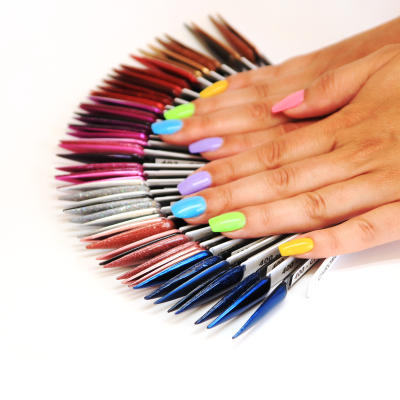 Mãos femininas com unhas em cores neon e amostras de unhas postiças coloridas em leque