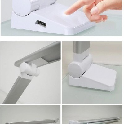 Lâmpada de mesa LED branca articulada com base e braço metálicos numa secretária