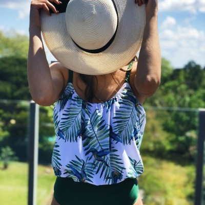 Mulher com fato de banho estampado e chapéu branco