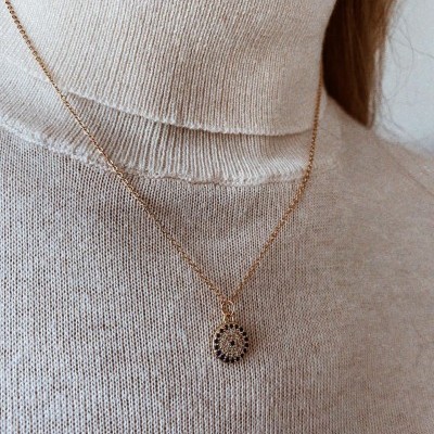 Colar dourado com pendente circular, camisola gola alta bege