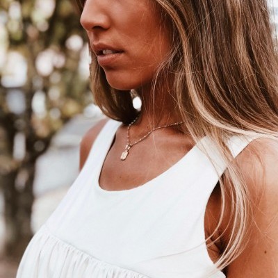 Vestido branco sem mangas com franzido usado por mulher ao ar livre