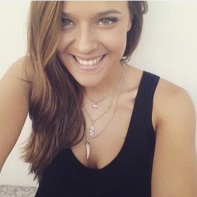 Colar prateado com três pendentes usado por mulher com top preto