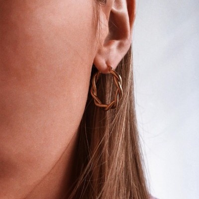 Brinco argola dourada entrelaçada na orelha