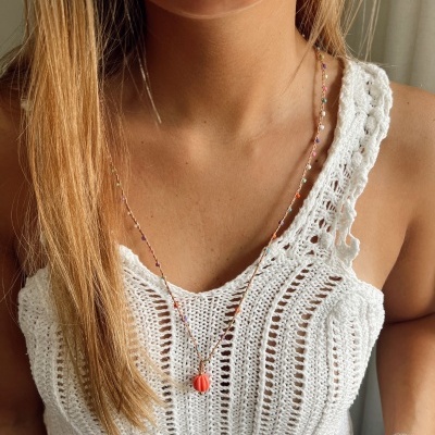 Colar colorido com pendente laranja e blusa branca de malha feita à mão