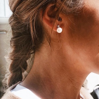 Mulher com brinco de pérola e cabelo em trança