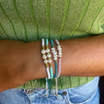 Três pulseiras de contas coloridas com pérolas no pulso