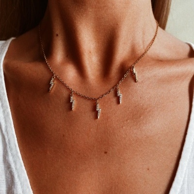Colar dourado com pendentes em forma de relâmpago
