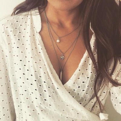 Colar duplo com pérola e elefante em blusa branca rendada