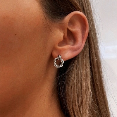 Brinco de argola torcido prateado na orelha