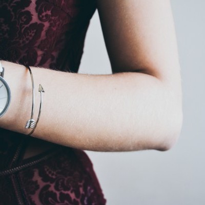 Relógio de pulso branco e pulseira dourada com vestido borgonha