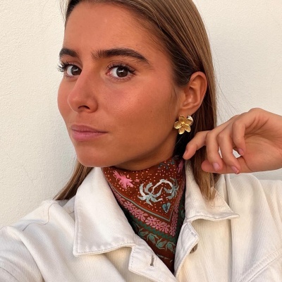 Brincos dourados de flor, cachecol colorido e casaco branco