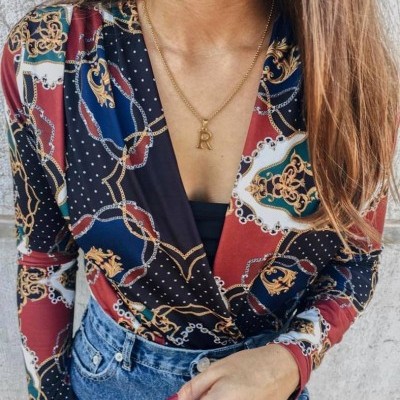 Blusa feminina colorida com padrão de correntes e colar dourado com letra R