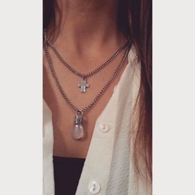 Colares femininos prateados com pendentes de cruz e pedra, camisa branca e camiseta preta.