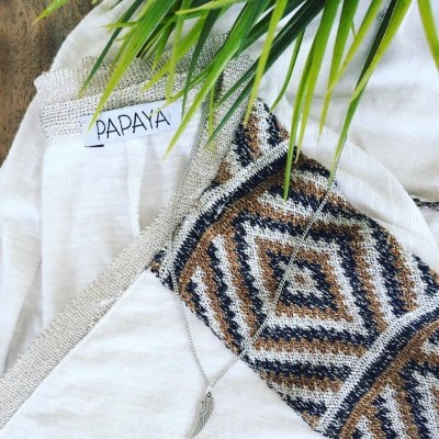 Peça de roupa branca com padrão geométrico e etiqueta PAPAYA