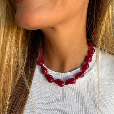Colar de pedras vermelhas polidas em pessoa com camisola branca
