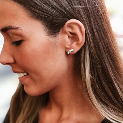 Brincos pequenos prateados em forma de flores com pedras brilhantes