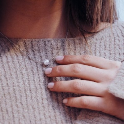 Colar delicado com pérola usado com camisola de malha bege