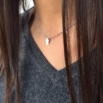 Colar prateado com pendente em forma de figura humana