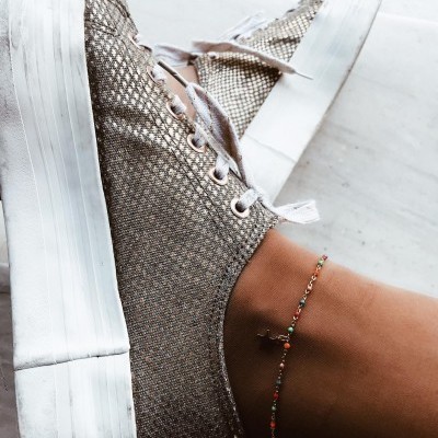 Ténis plataforma metálico prateado com sola branca e pulseira colorida no tornozelo