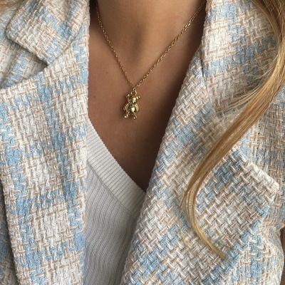 Colar dourado com pendente de ursinho e casaco xadrez azul branco bege