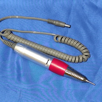 Caneta elétrica para manicure com cabo espiral sobre tecido azul