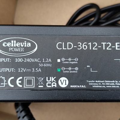 Adaptador de energia preto com etiqueta de especificações técnicas e certificações