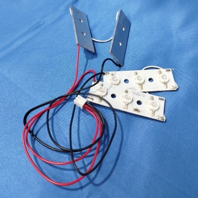 Placas eletrónicas com LEDs, fios e peças metálicas sobre tecido azul