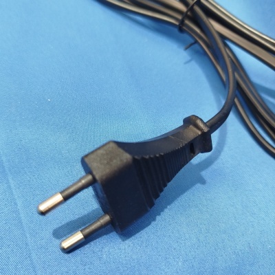 Ficha elétrica preta de duas pontas sobre fundo azul