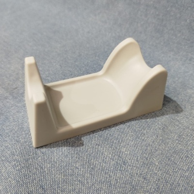 Suporte branco em plástico sobre tecido azul.