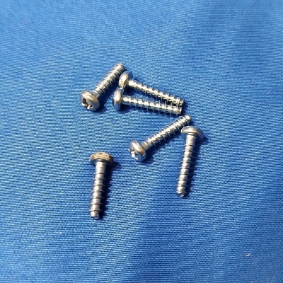 Seis parafusos de metal sobre tecido azul