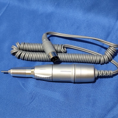 Broca elétrica profissional prateada com cabo cinza em espiral sobre tecido azul