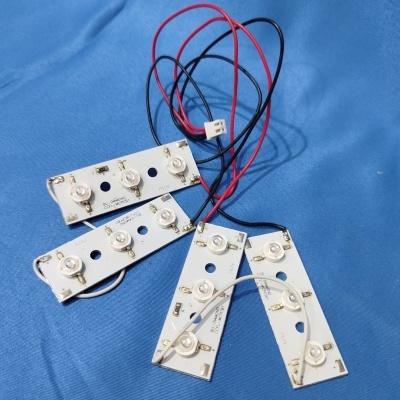 Placas eletrónicas brancas com LEDs e fios sobre tecido azul