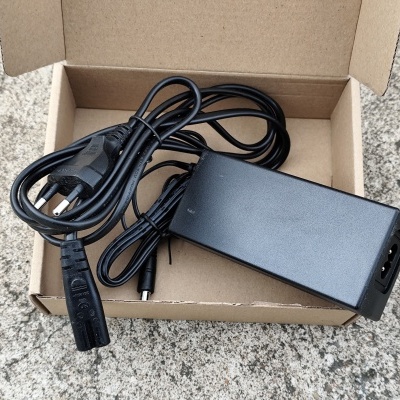 Adaptador de alimentação preto com cabo elétrico e ficha europeia na caixa de cartão