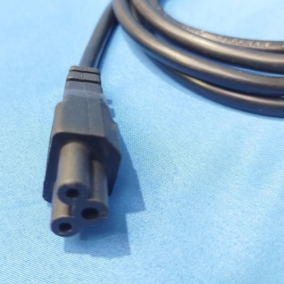 Cabo elétrico preto com conector de três pinos sobre fundo azul