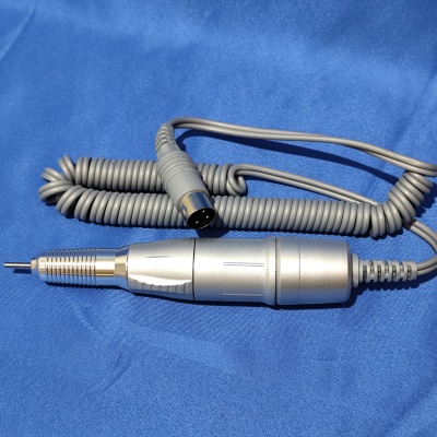 Broca elétrica profissional prateada com cabo cinza em espiral sobre tecido azul