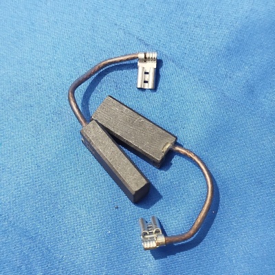 Escovas de carvão com cabos e terminais metálicos sobre fundo azul