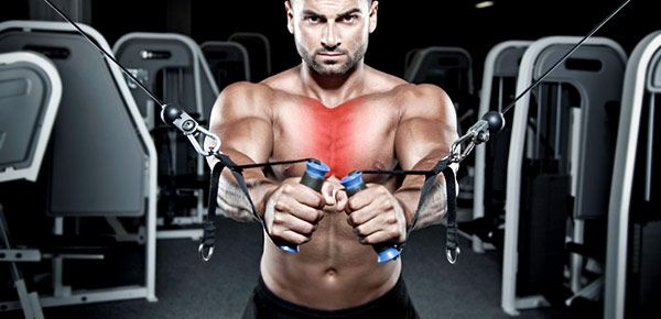 Homem musculado a usar máquina de exercício com cabos no ginásio