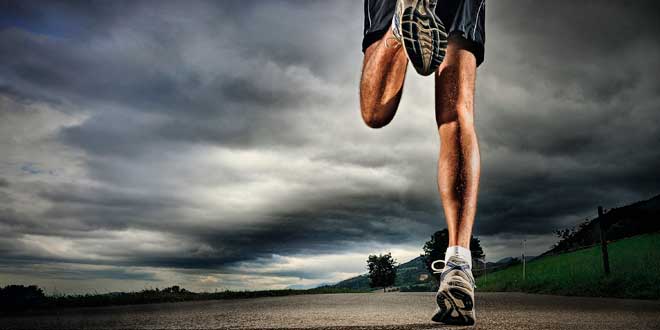 Pessoa a correr numa estrada ao ar livre sob céu nublado