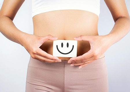 Pessoa a segurar bloco com sorriso desenhado ao nível do abdómen