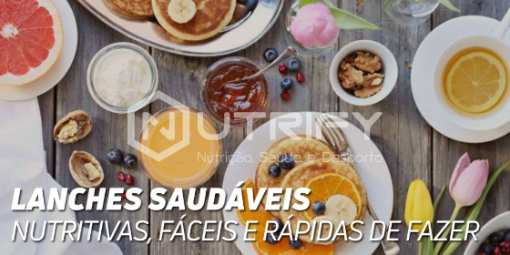 Mesa com alimentos saudáveis como panquecas, frutas, sumo, iogurte e nozes.