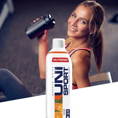 Mulher com bidão preto e bebida Nutrend UNI SPORT de sabor laranja em embalagem branca