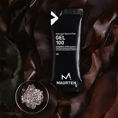 Pacote preto de gel energético Maurten sobre folhas castanhas